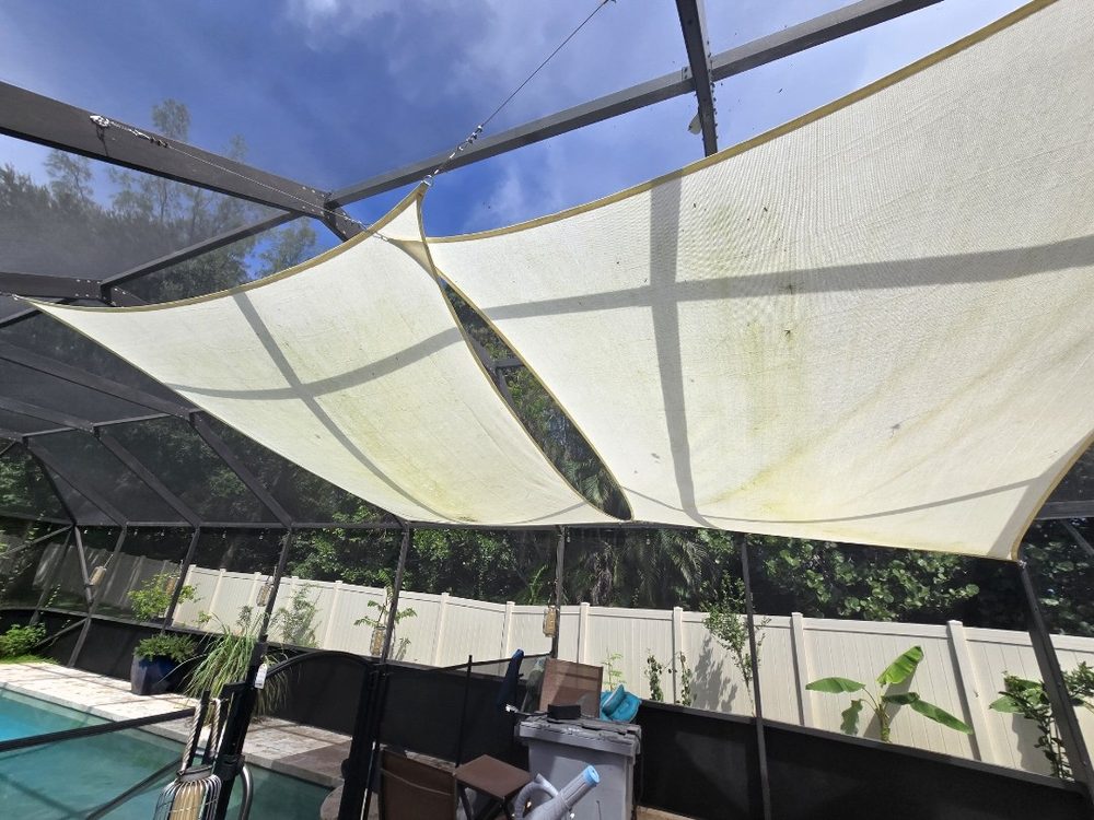 Shade sail stained with green mildew before cleaning